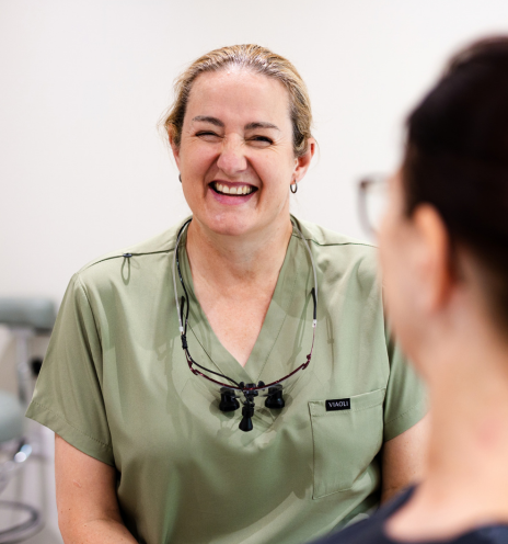 Smiling dentist talking with a patient – general dentistry
